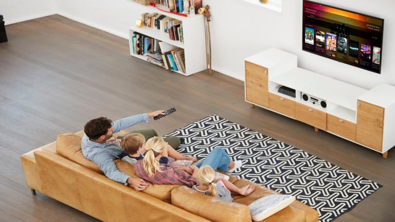 family sitting on a couch navigating the plex interface on a TV