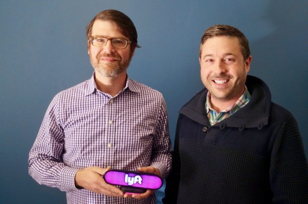 Igor Institute co-founder and VP of Engineering Sean Murphy (left) and co-founder and CEO Aren Kaser (right) with the new Lyft Amp device. (GeekWire Photo / Todd Bishop)