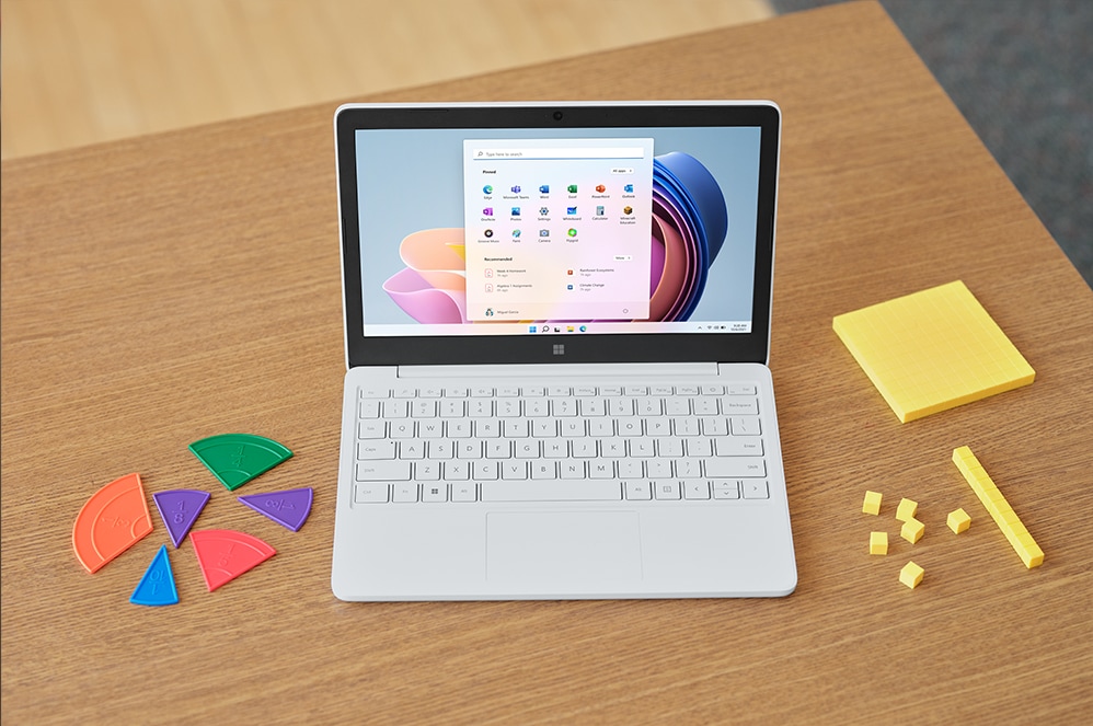 Surface Laptop SE on a desk next to educational accessories.